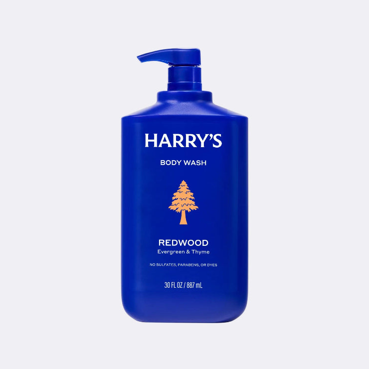 Blue bottle of Harry's body wash with pump dispenser on a light gray background
