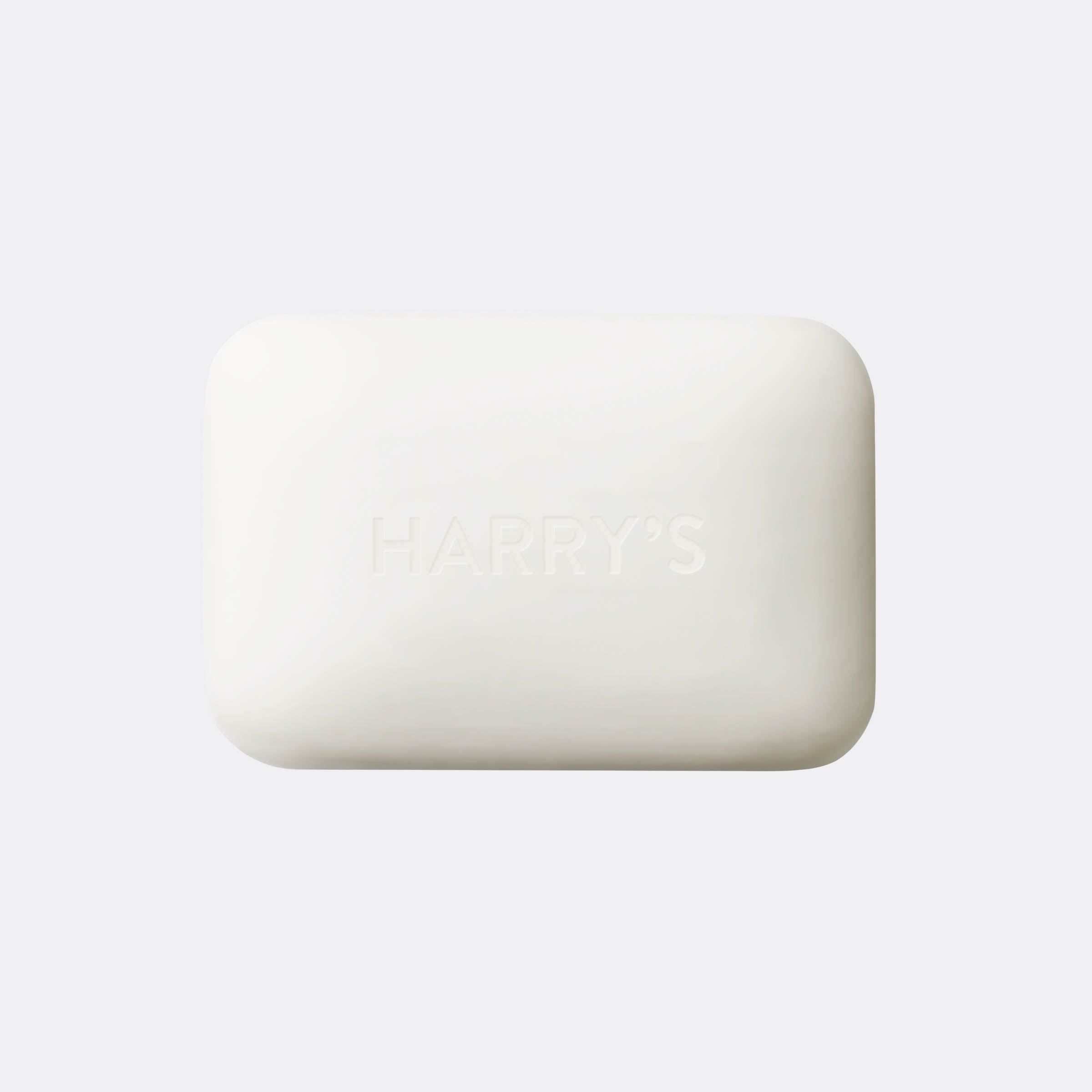 A rectangular bar of Harry's soap with rounded corners, embossed with the brand name, shown on a light gray background.