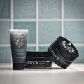 Three containers of 'Harry's Tattoo Frost' on a tiled bathroom counter.