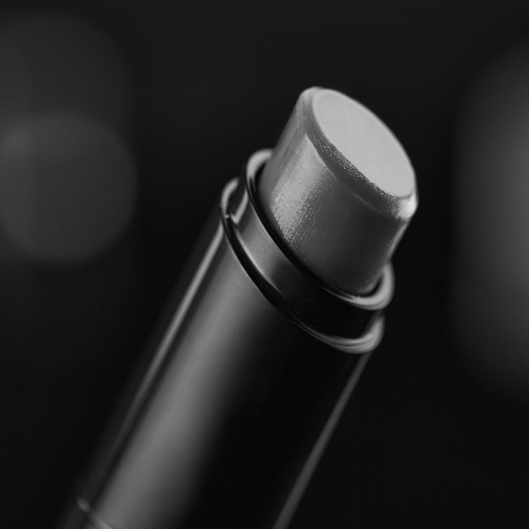 Close-up of a black lip balm on a dark background