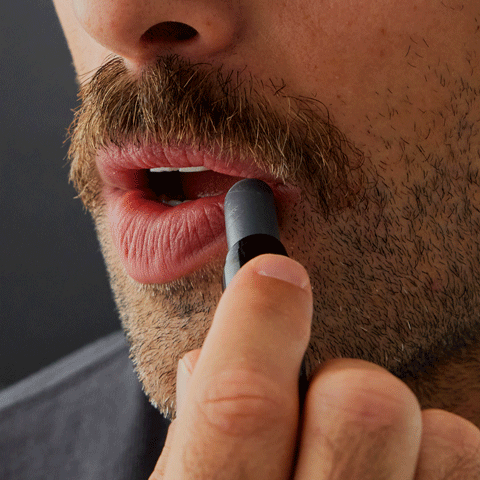 Gif of a person using the lip balm on their lips.