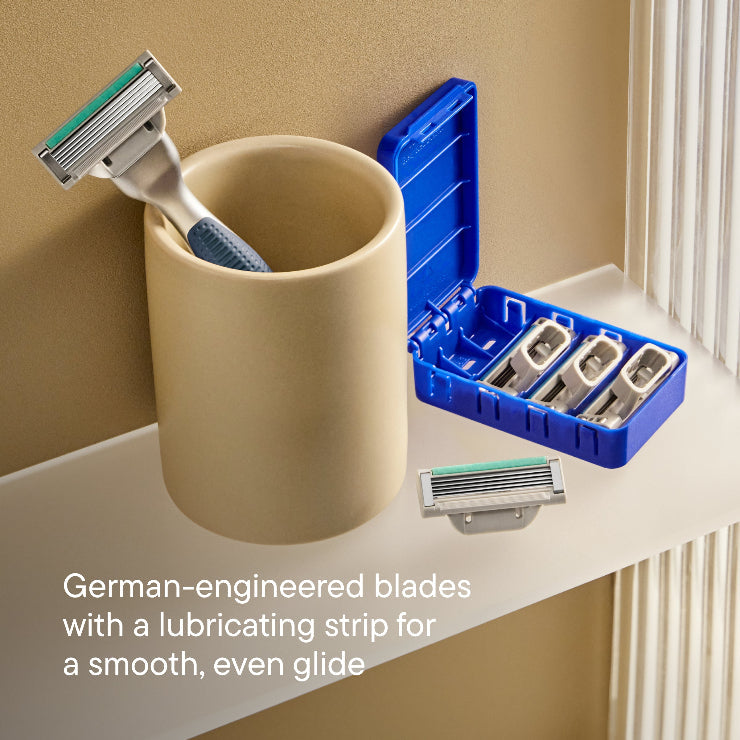 Harry's Plus Razor handle resting in a ceramic cup next to the Harry's Plus blade cartridges in their protective packaging.