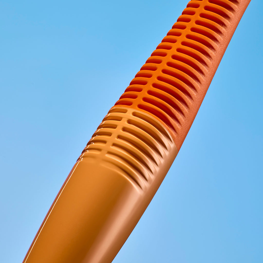 Close-up of an orange ribbed plastic tube or handle against a solid light blue background.